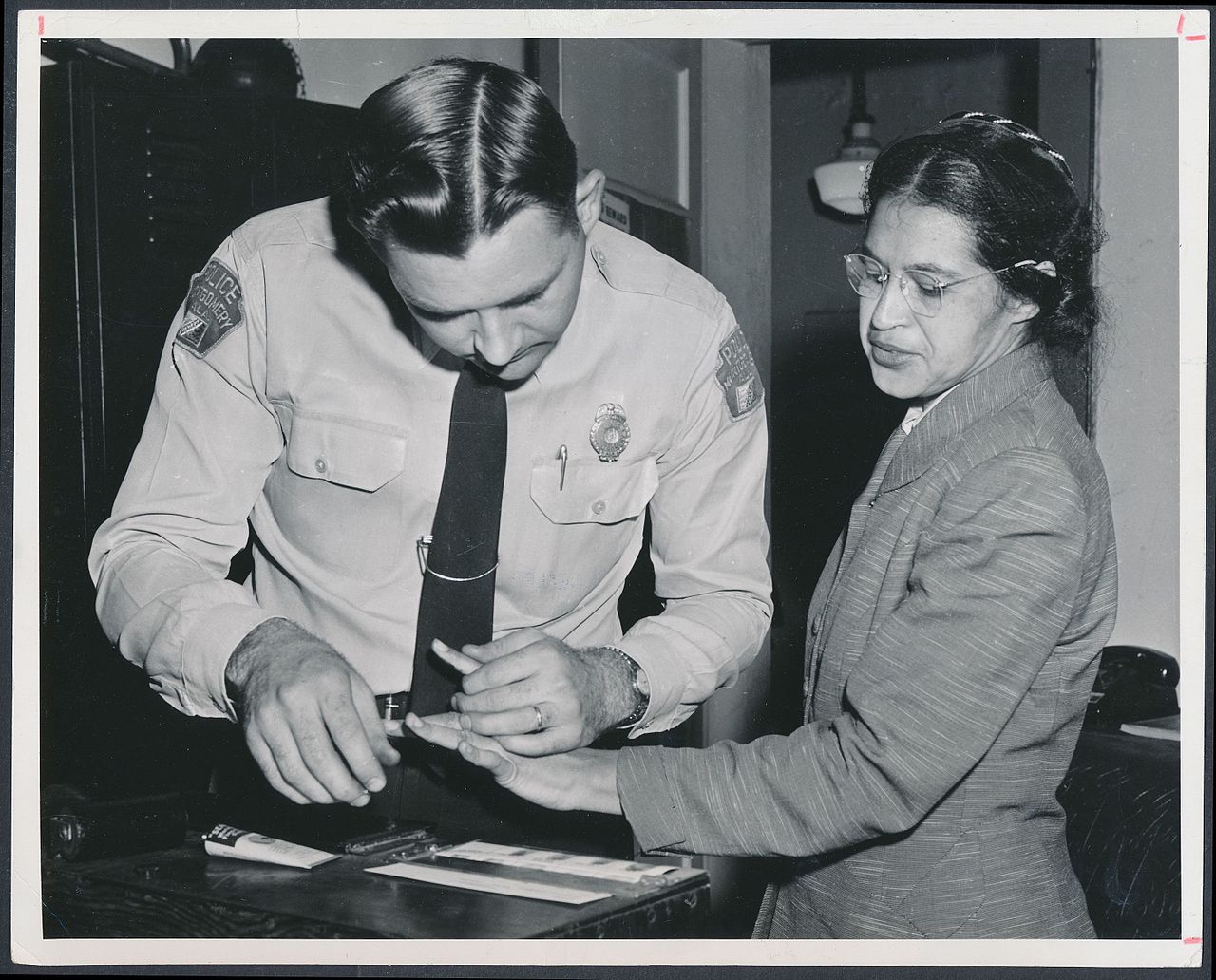 Rosa Parks being fingerprinted by Deputy Sheriff D.H. Lackey (By Associated Press (http://www.rmyauctions.com/lot-8002.aspx) [Public domain], via Wikimedia Commons)